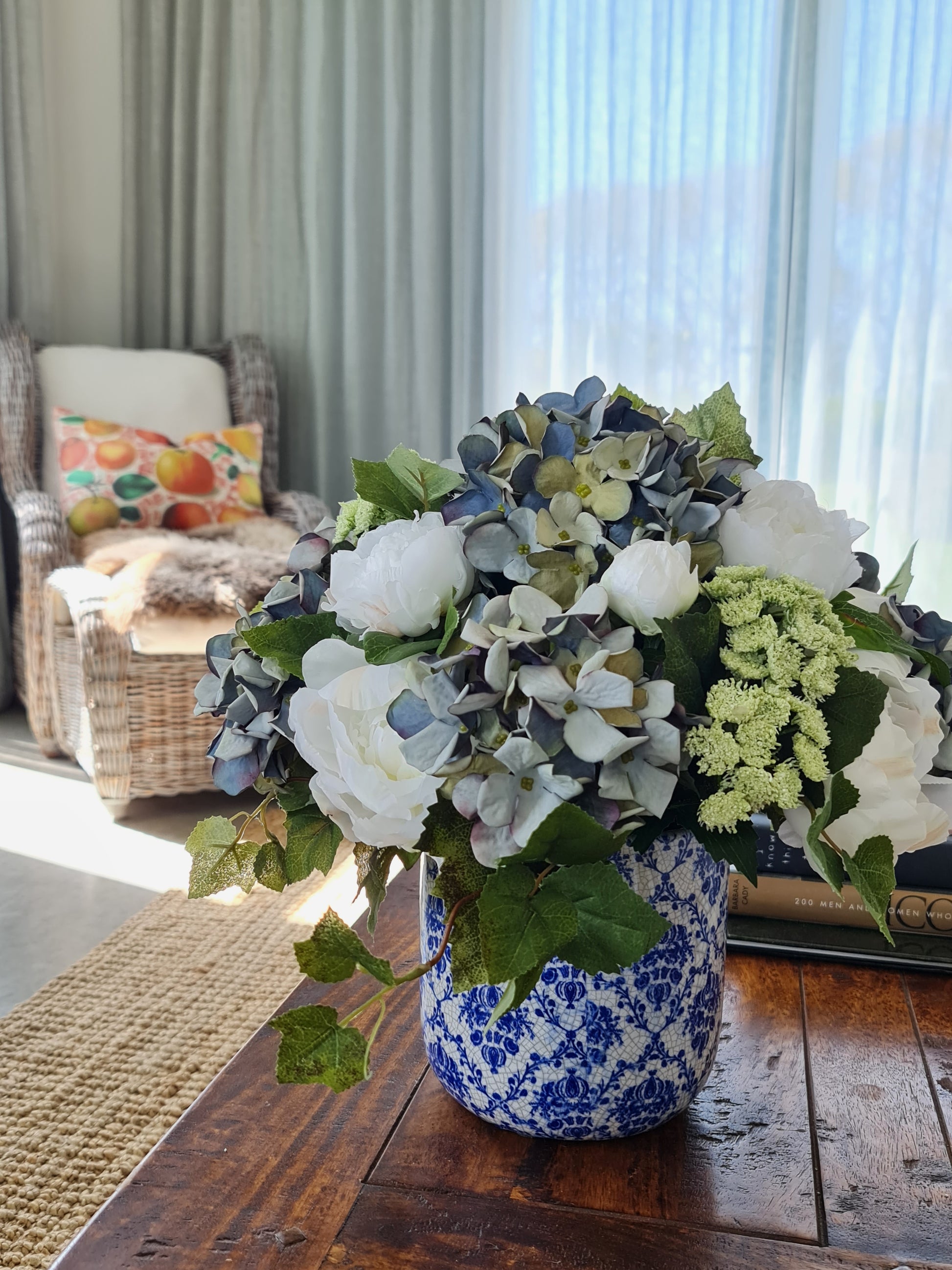 white artificial flowers peony and artificial blue hydrangea in blue and white aged ceramic vase