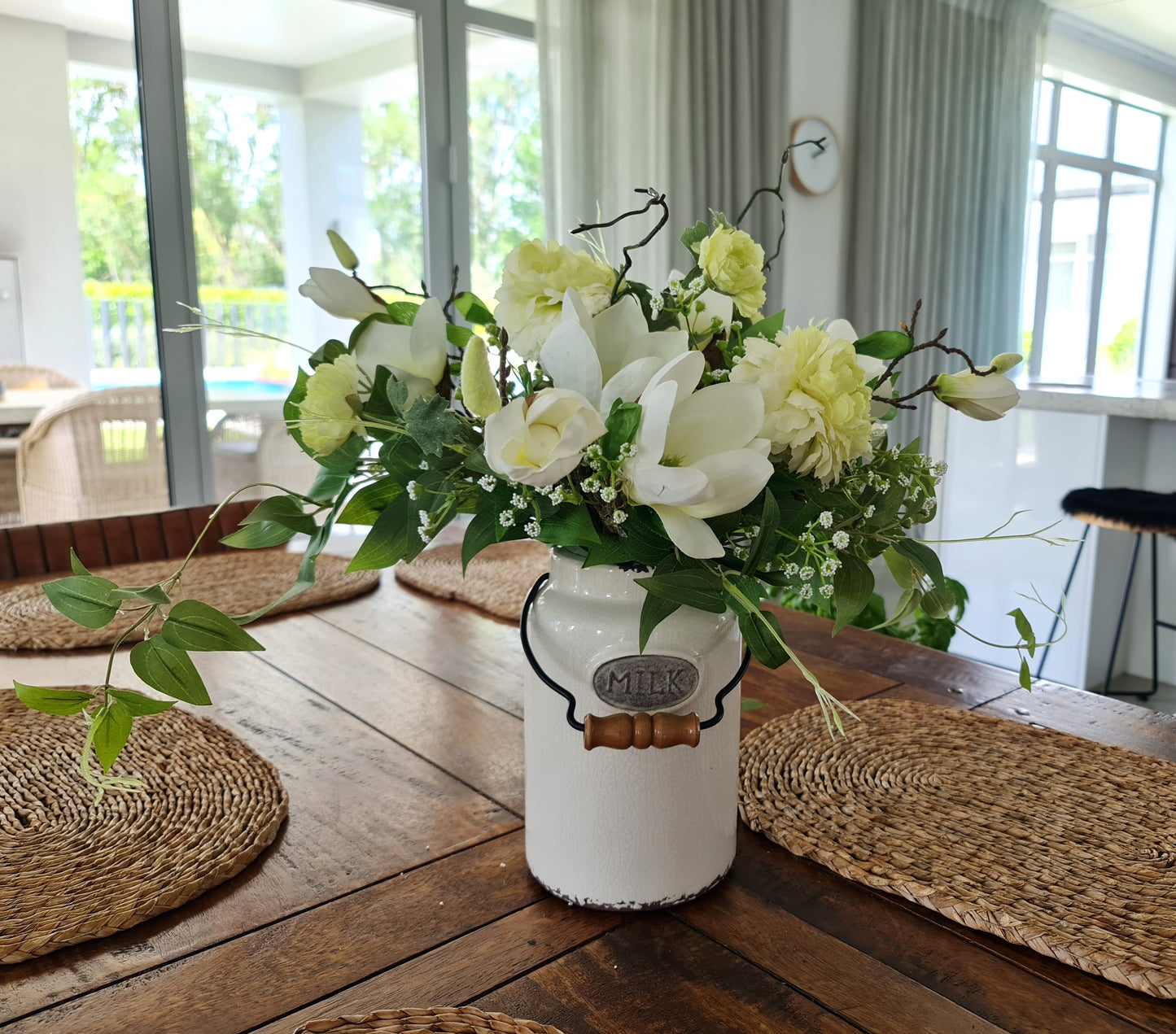 artificial white magnolia white ranunuculus floral arrnangement in aged antique cream milk churn