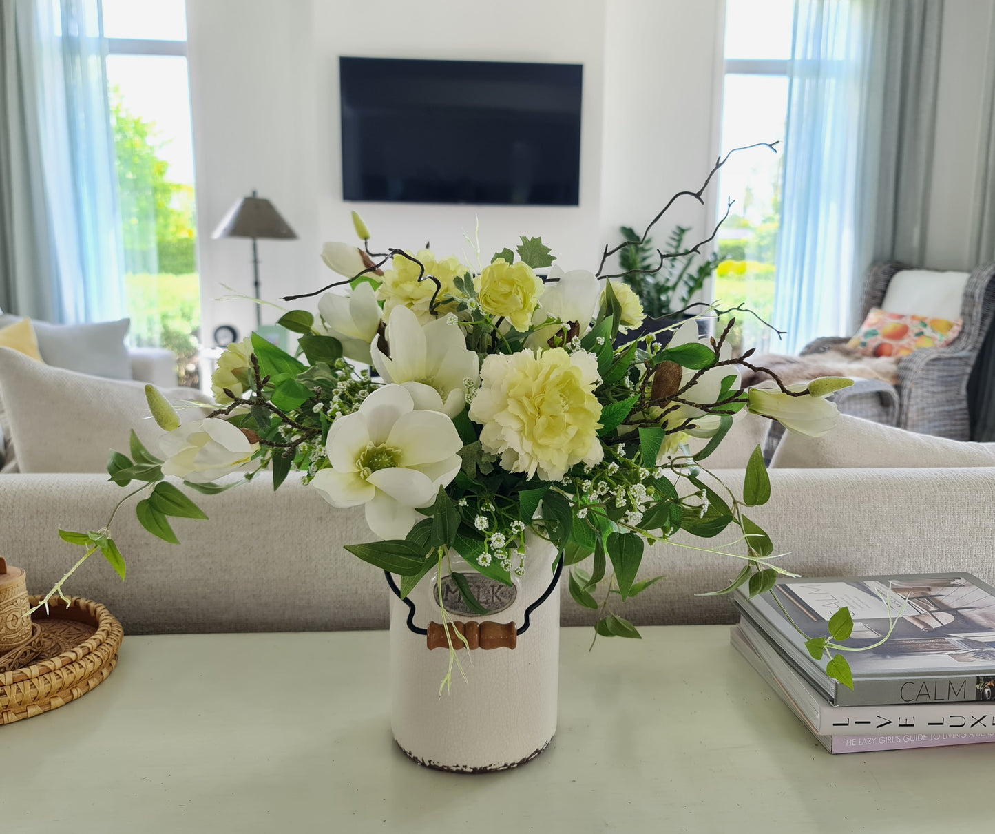 artificial white magnolia white ranunuculus floral arrnangement in aged antique cream milk churn