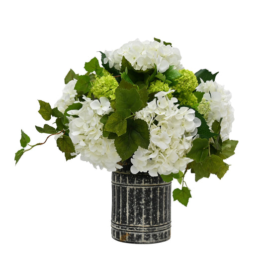 silk floral arrangement set into black rustic tin urn with white hydrangeas and snowball flowers