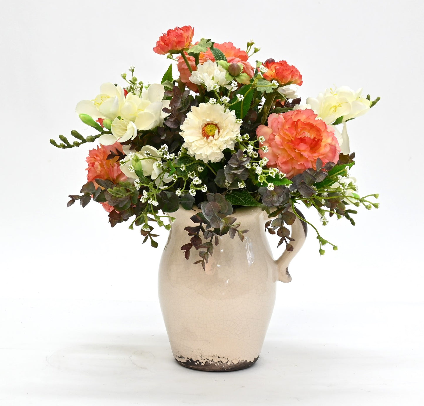 artificial peach ranunculus white freesia white gypsopholia floral arrangement in aged cream ceramic jug 